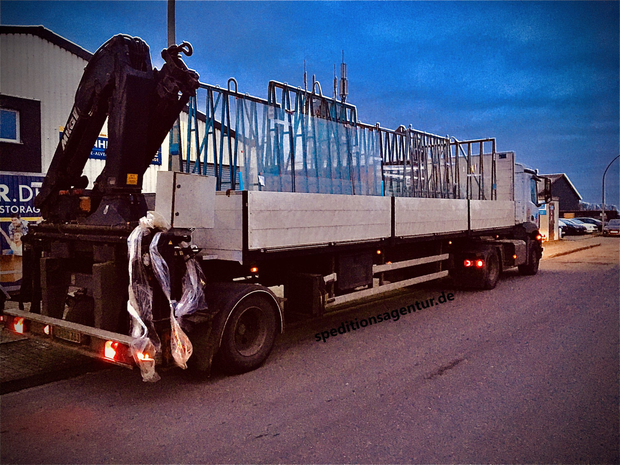 Glasscheiben werden per Bordkran auf LKW verladen