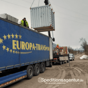 Kran verlädt Container in LKW mit offenem Edscha Verdeck
