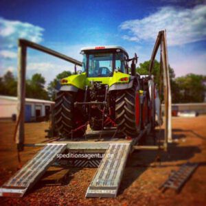 Traktor auf verbreiterbaren Tieflader